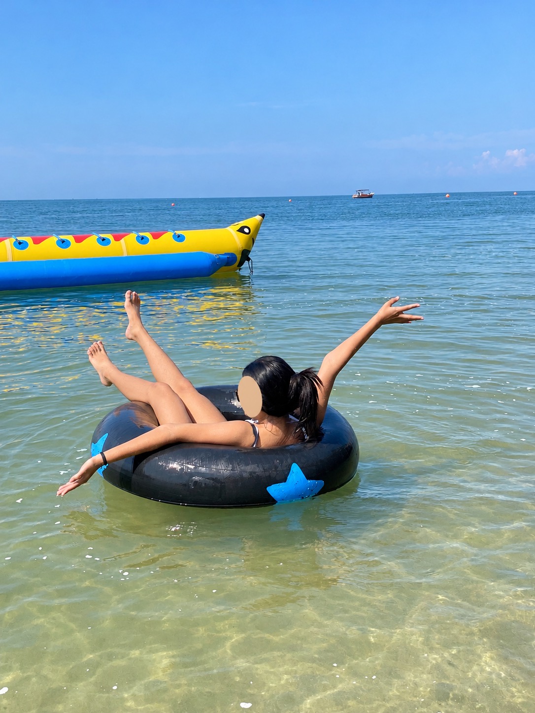 Floating in an inflatable ring at Bang Saen Beach with face covered