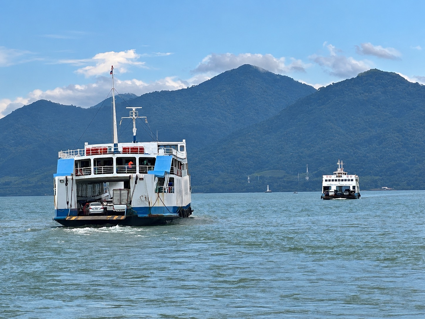 Two vehicle ferries crossing with Koh Chang hills behind