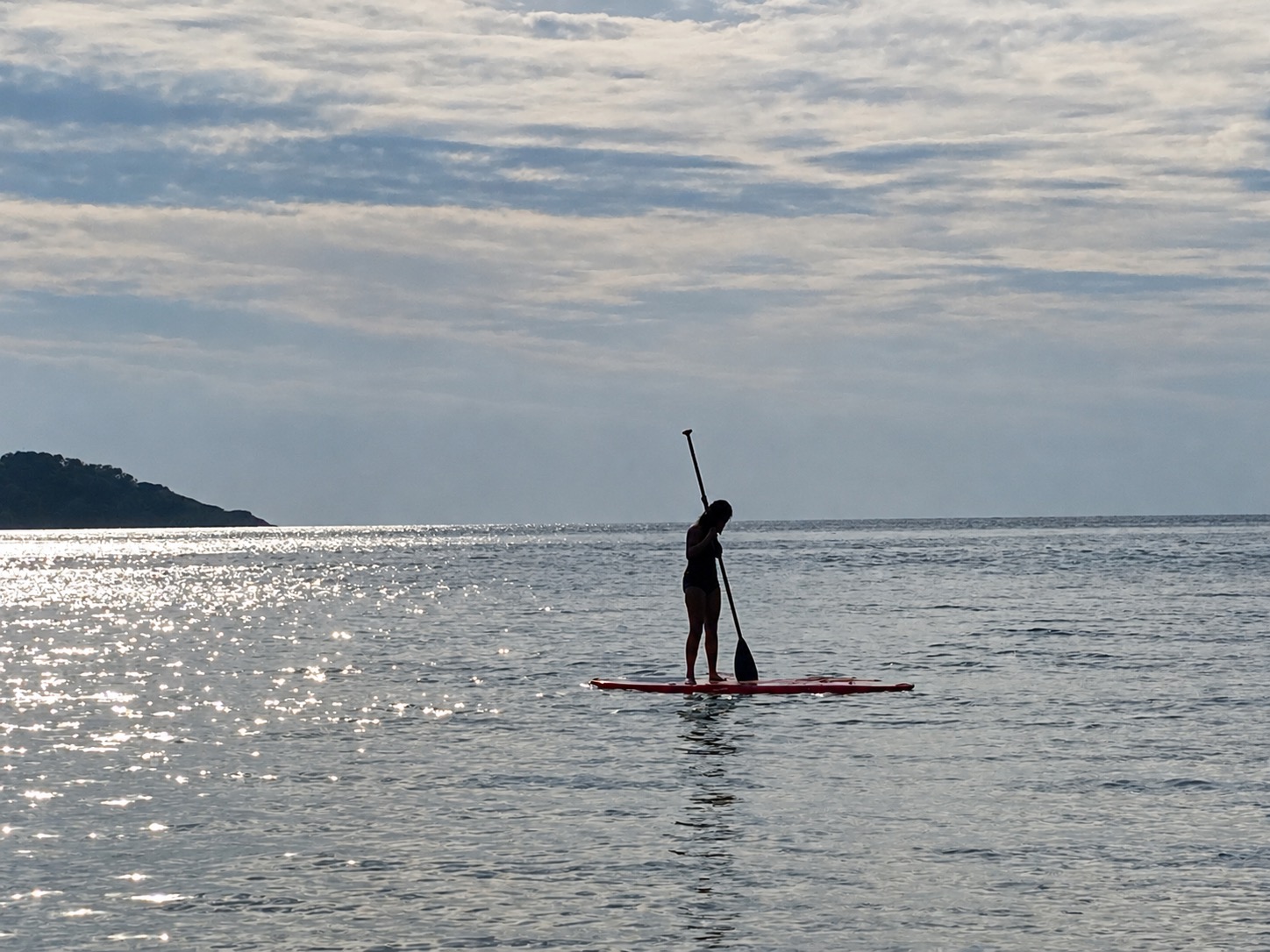 Paddleboarder silhouetted on the sea